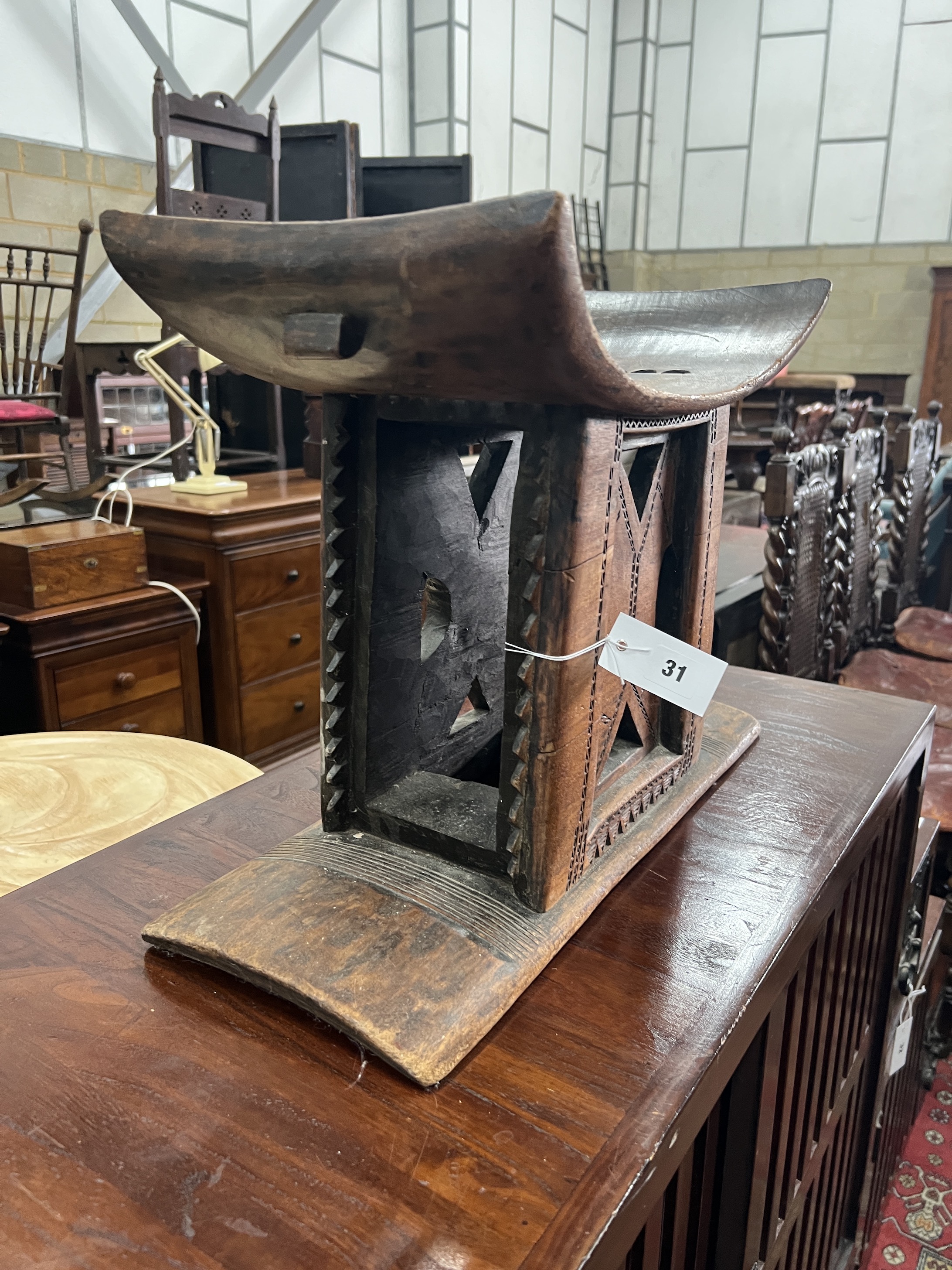 An African Ashanti style chip carved stool, width 55cm, depth 22cm, height 39cm
